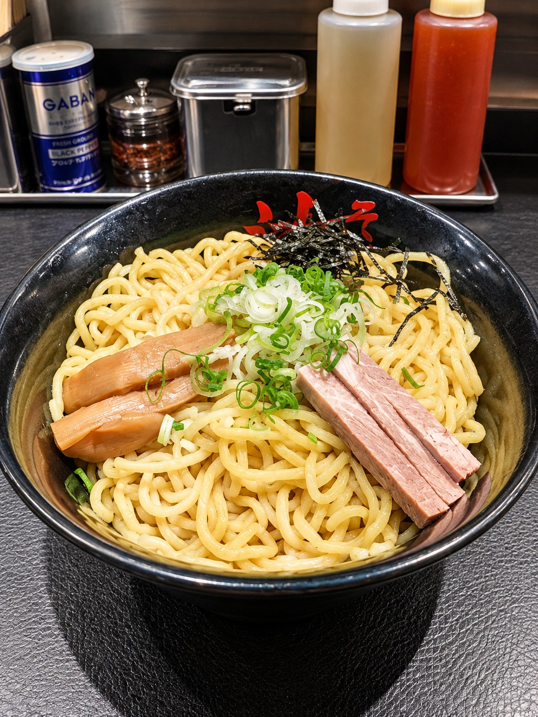 東京油組総本店 立川若葉町組の油そば。メンマ・チャーシュー・刻み玉ねぎ・焼のりがのった一杯